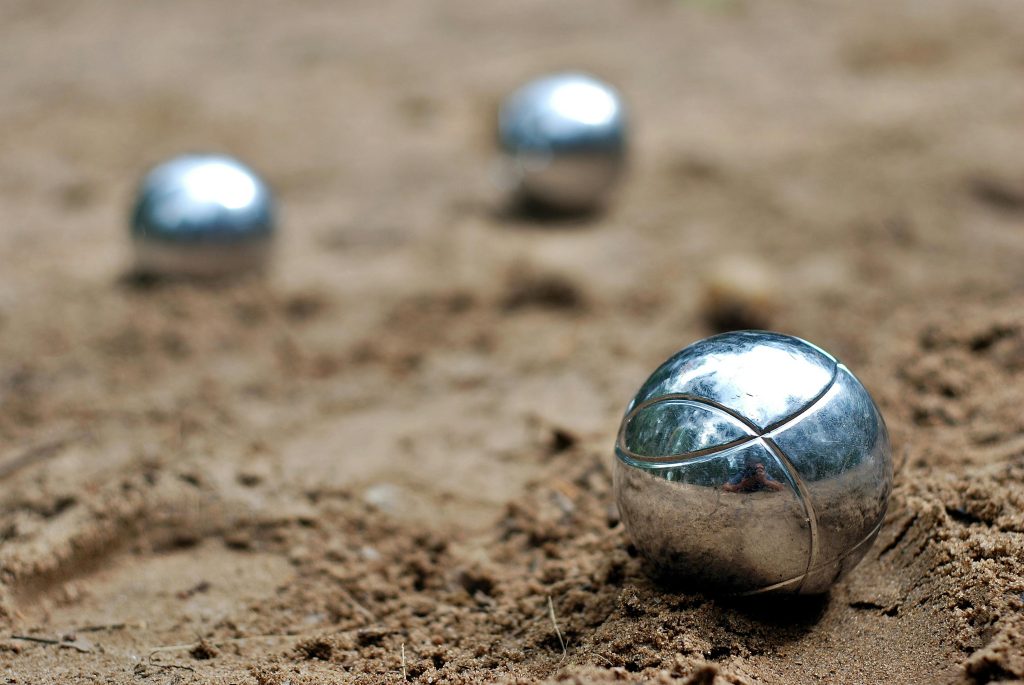 Close-up of shiny petanque balls on a sandy beach. Perfect for outdoor and leisure themes.