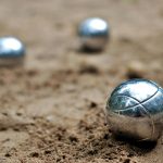 Close-up of shiny petanque balls on a sandy beach. Perfect for outdoor and leisure themes.